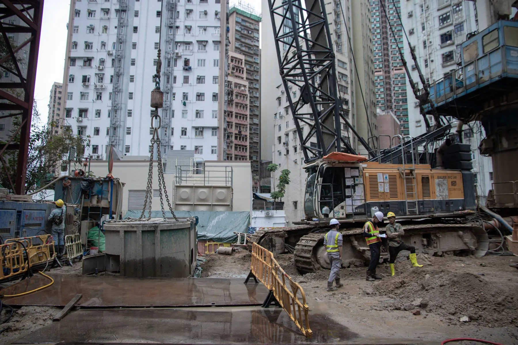 Active urban construction site with workers and heavy equipment